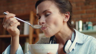 女人吃cornflaces牛奶厨房女孩享受麦片早餐